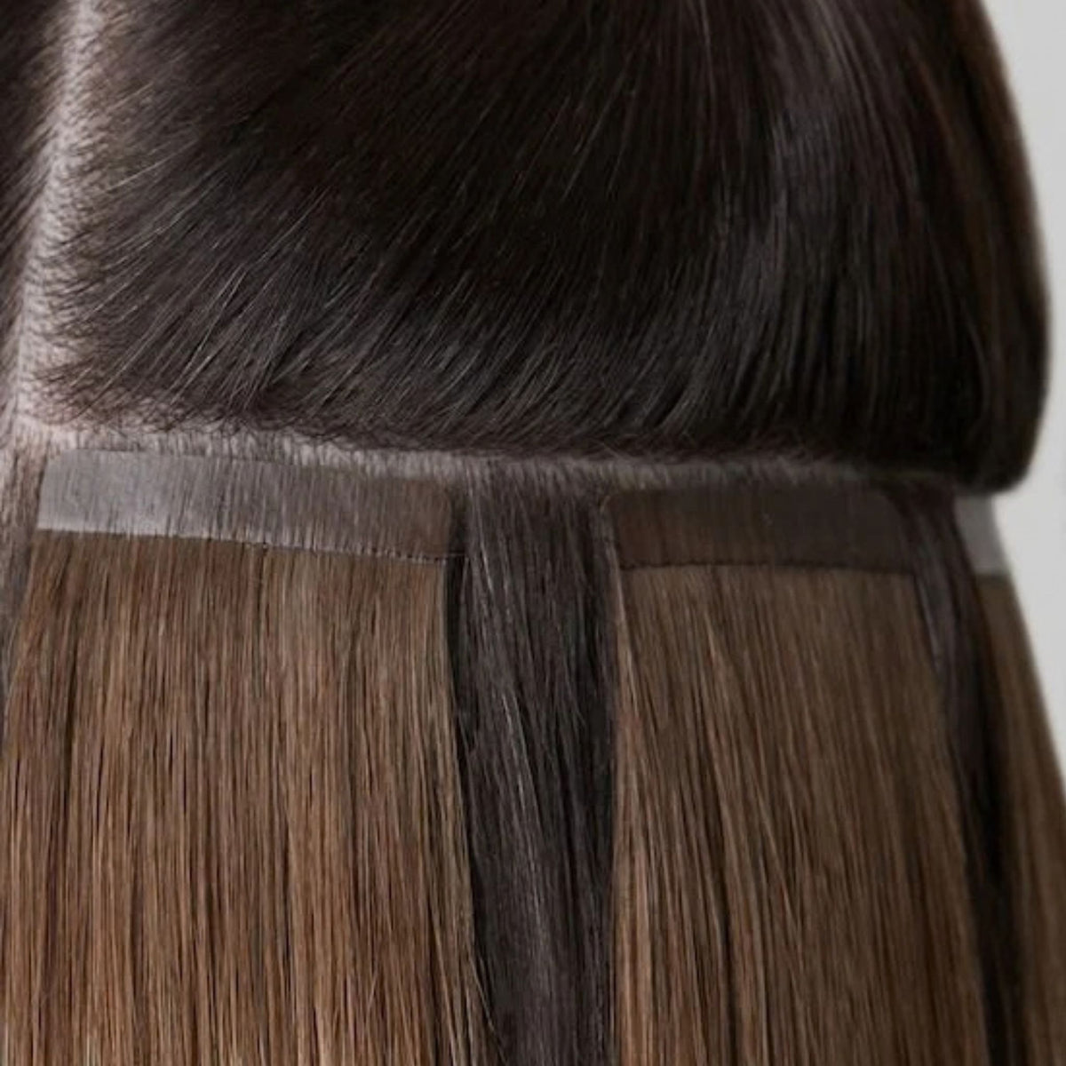 Detalle de las cintas adhesivas de las extensiones castañas